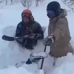 video-|-russische-skiers-halen-vriendin-onder-dik-pak-sneeuw-vandaan